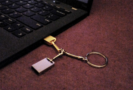 A photo of the two small usb drives on a keychain ring, one of them is plugged in